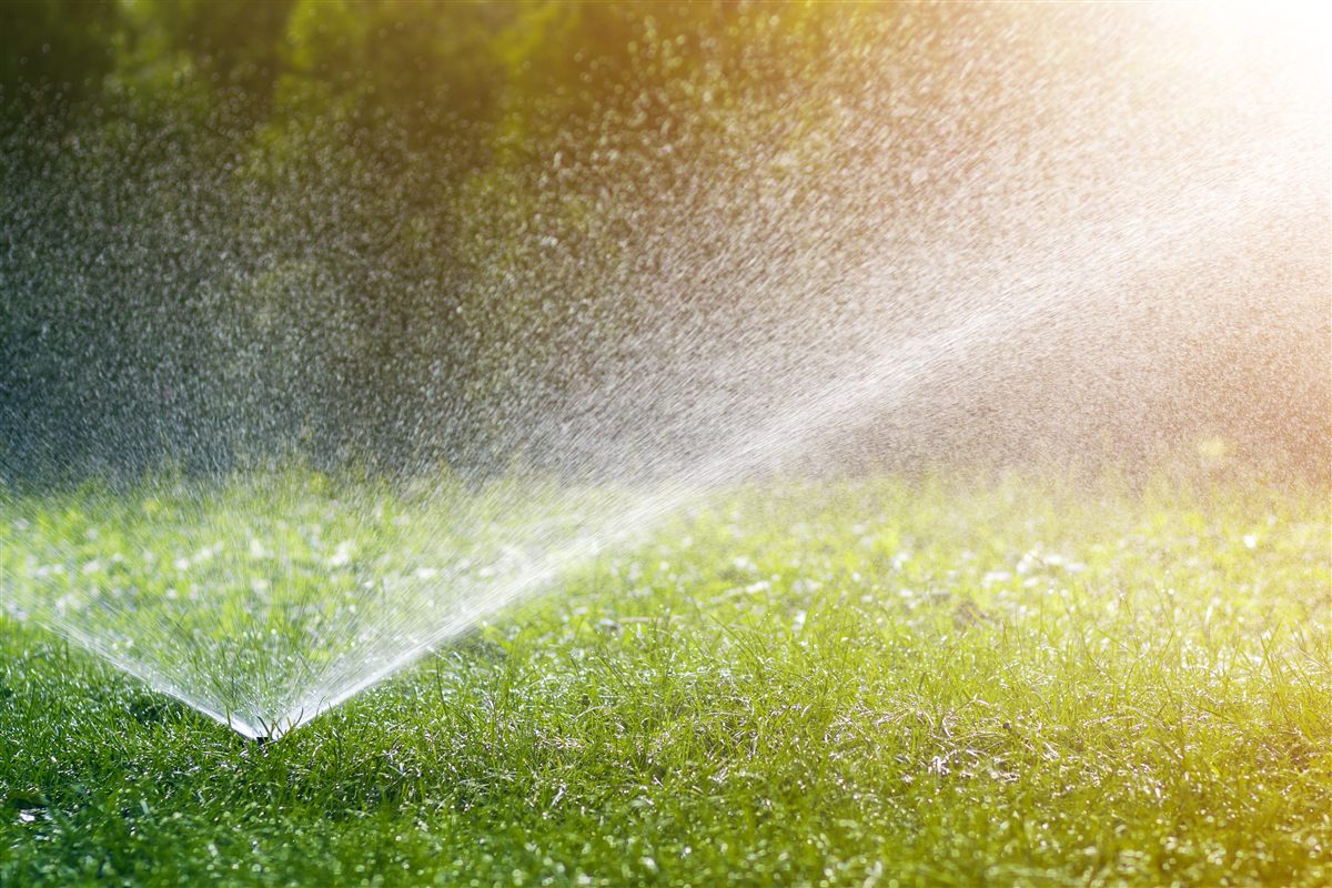Lawn sprinkler spraying water over green grass — sprinkler system services by Brunner Landscape & Lawn Sprinkler in Northeast Ohio